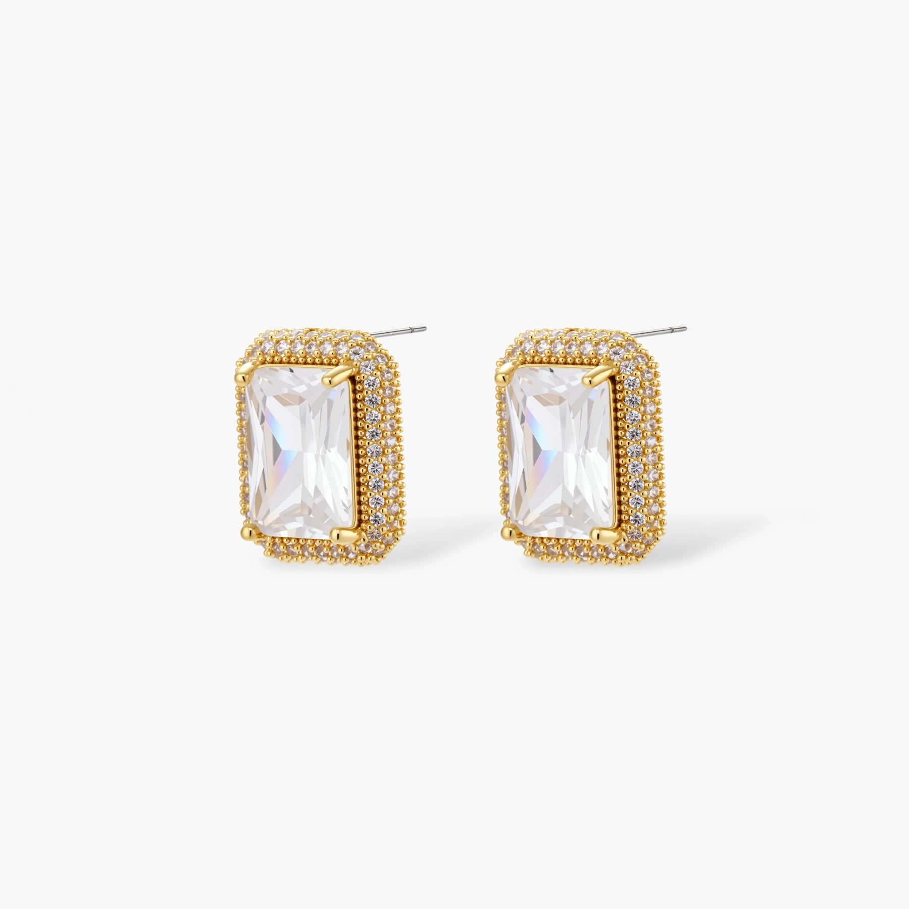 Gold-plated jewelry set with rectangular cubic zirconia stones in pave halo settings on cream background