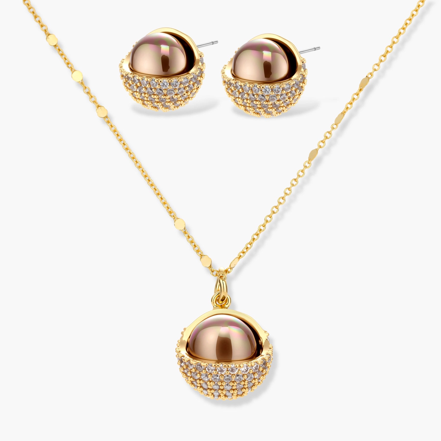 Elegant spherical pendant necklace and earrings set featuring crystal-pavé bottom half in gold or silver finish on white background.