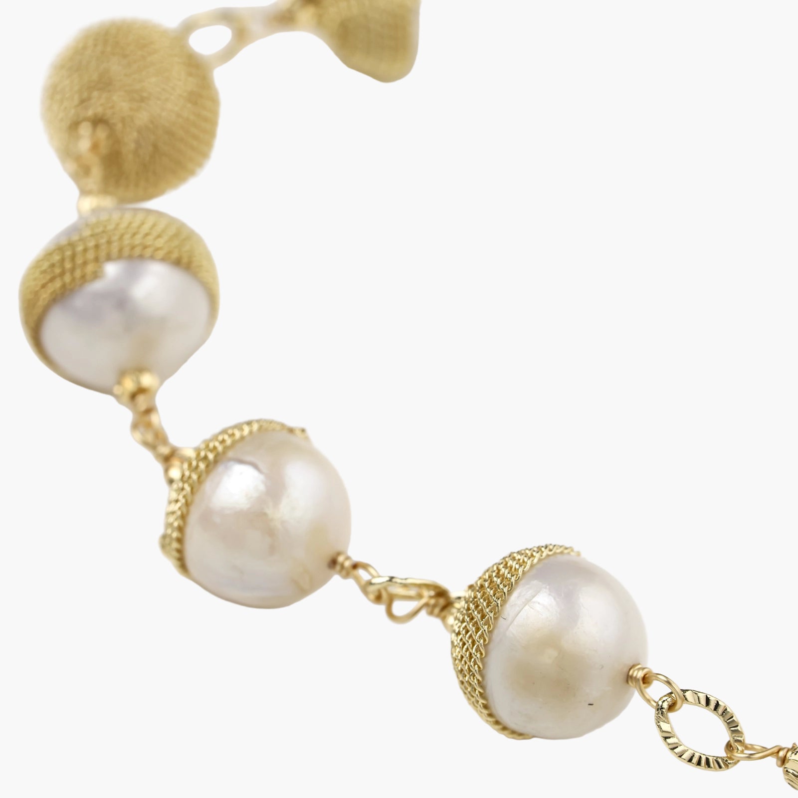 Adjustable bracelet with baroque pearls wrapped in delicate gold mesh netting connected by textured chain links