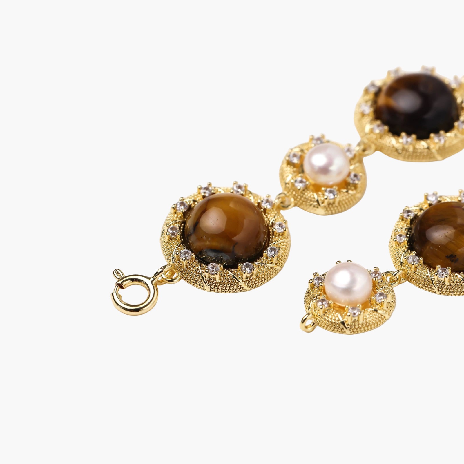 Gold-plated link bracelet with alternating brown tiger's eye stones and white freshwater pearls in ornate bezels.