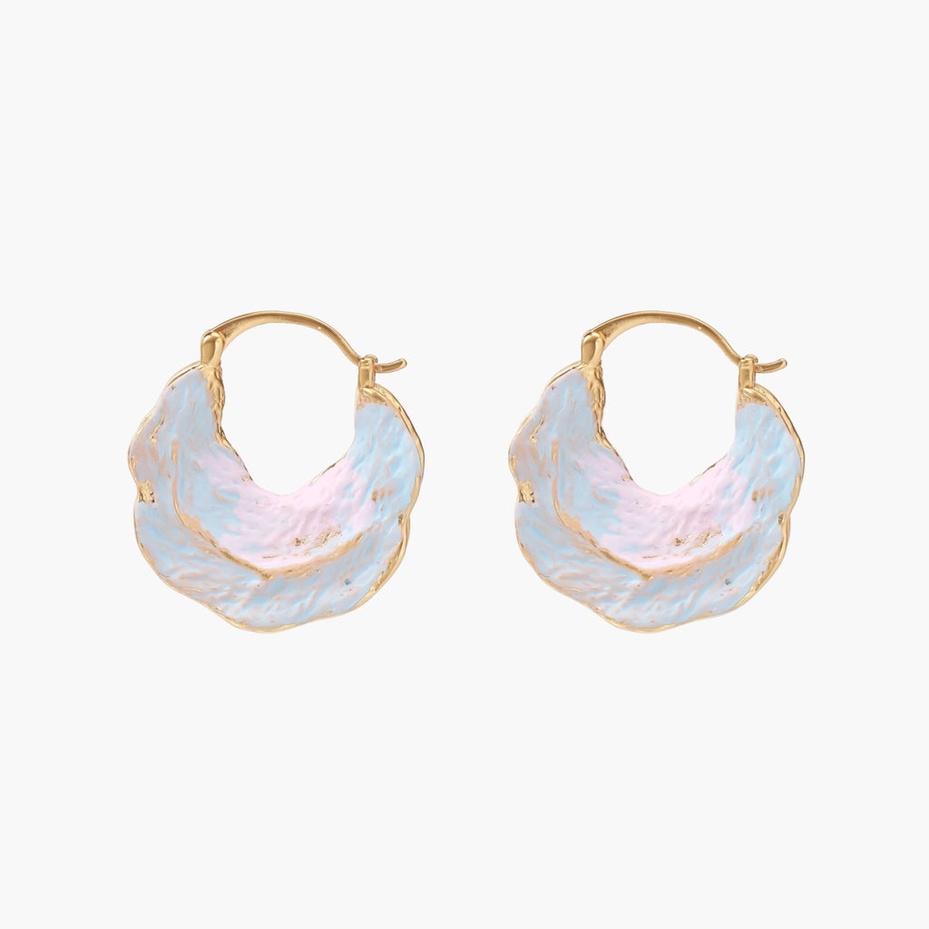 Shell-shaped hoop earrings with iridescent blue-pink enamel and gold trim on cream background