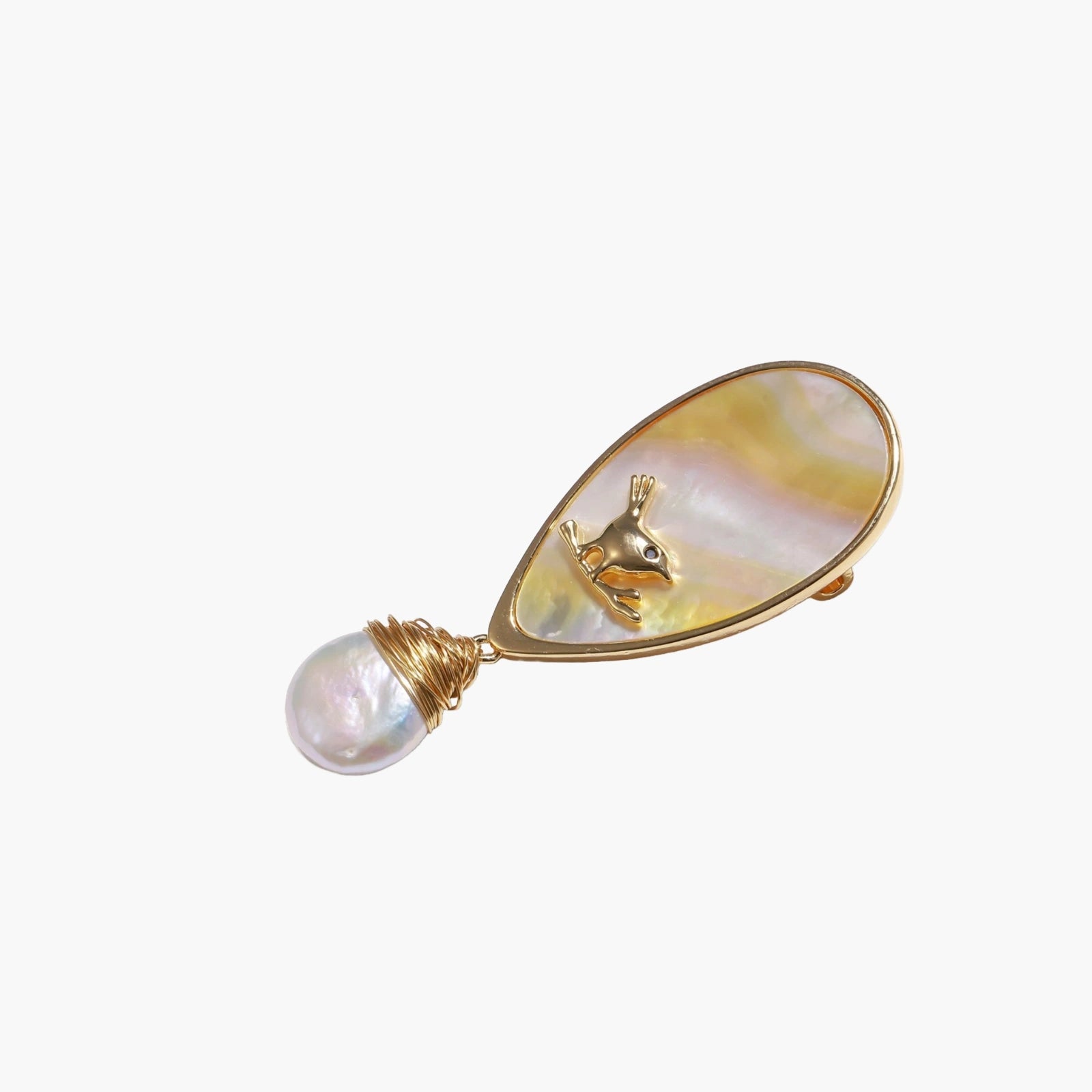Iridescent shell brooch with gold bird accent and wire-wrapped baroque pearl drop on cream background.