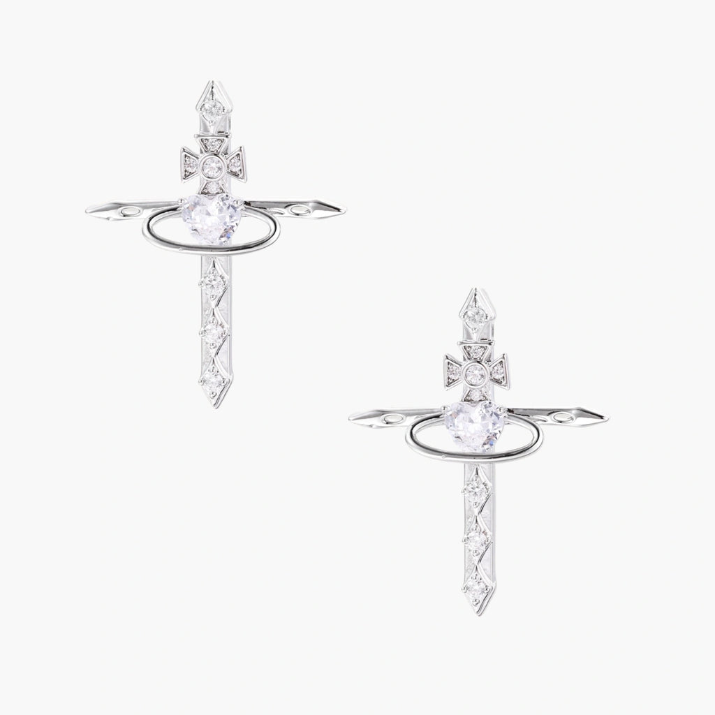 White gold plated cross earrings with orbital ring & zirconia stones on cream background