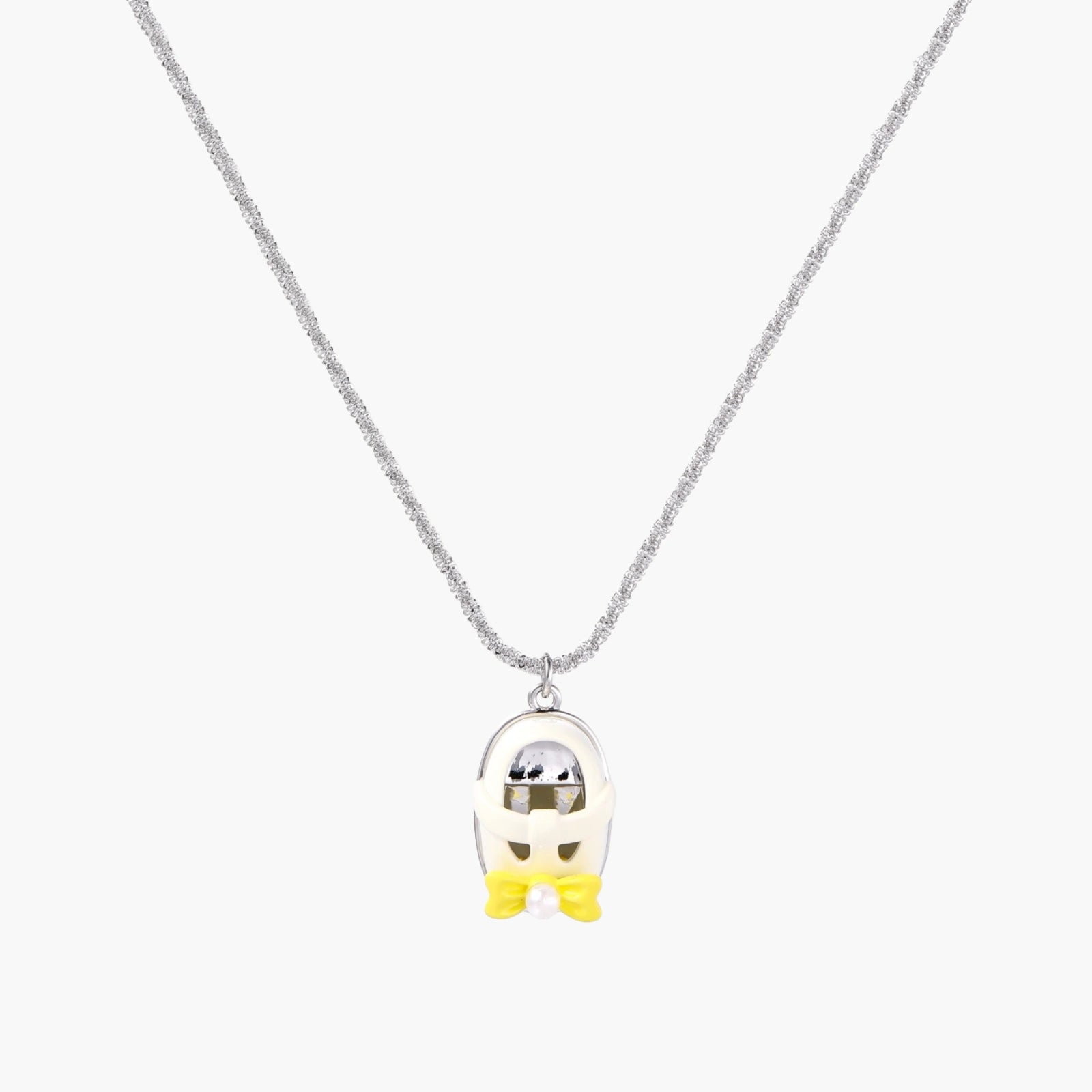 Chrome egg-shaped pendant with kawaii face, yellow bow, and pearl detail on silver chain against white background