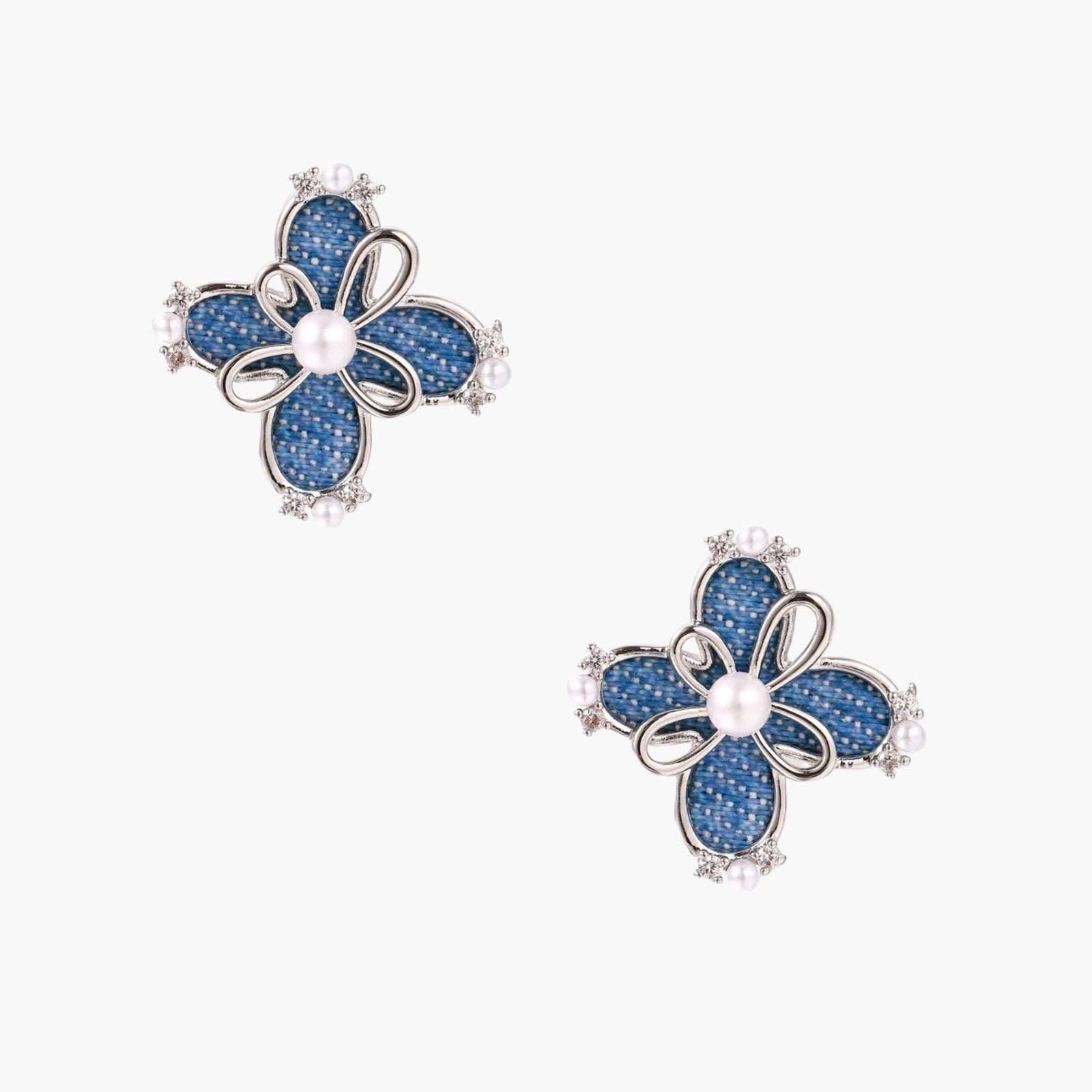 Blue denim fabric flower studs with white gold plated petals, pearl center, and zirconia accents on white background