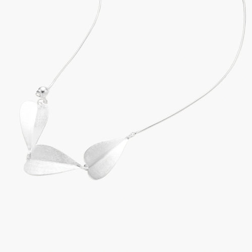 Minimalist sterling silver necklace with three brushed leaf-shaped pendants on delicate chain against white background