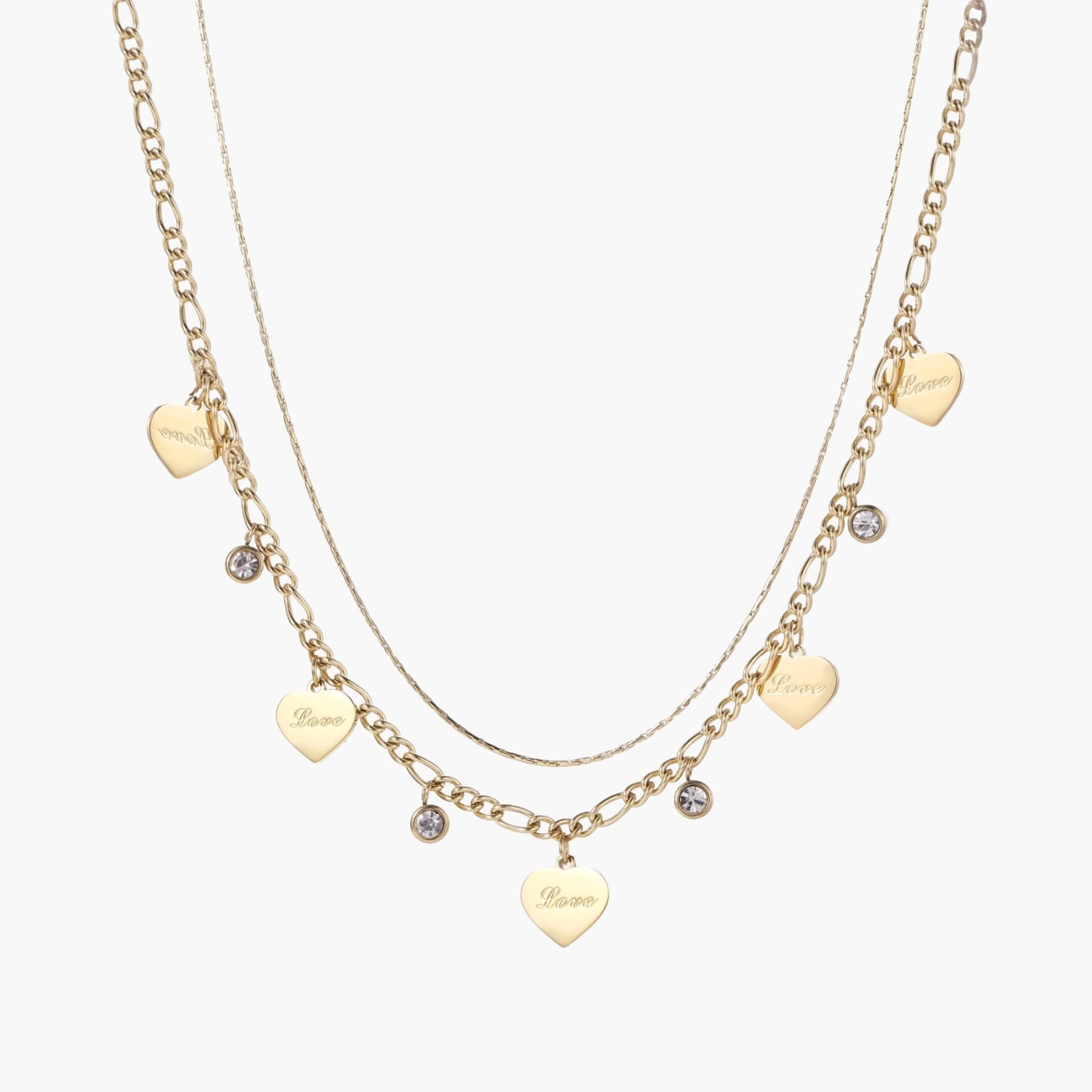 Gold layered necklace set with engraved heart pendants and crystal accents on cream background