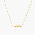 Dainty 18K gold plated necklace with infinity knot pendant on delicate chain against white background