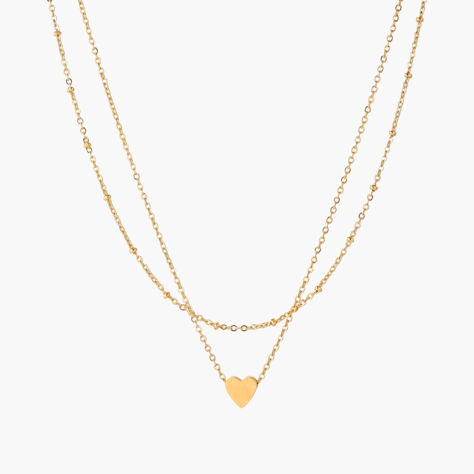 Delicate double-chain gold necklace with tiny heart pendant on cream background