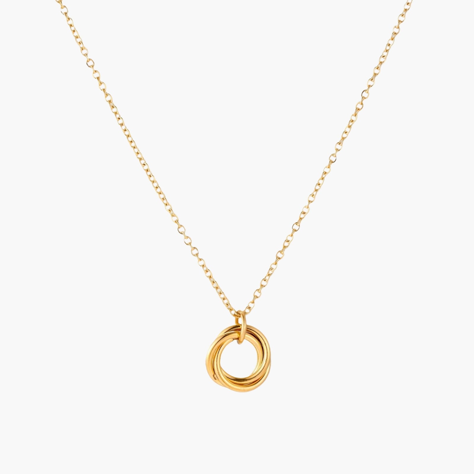 Delicate gold-plated necklace with three interlocking circle rings forming a minimalist knot pendant on cream background