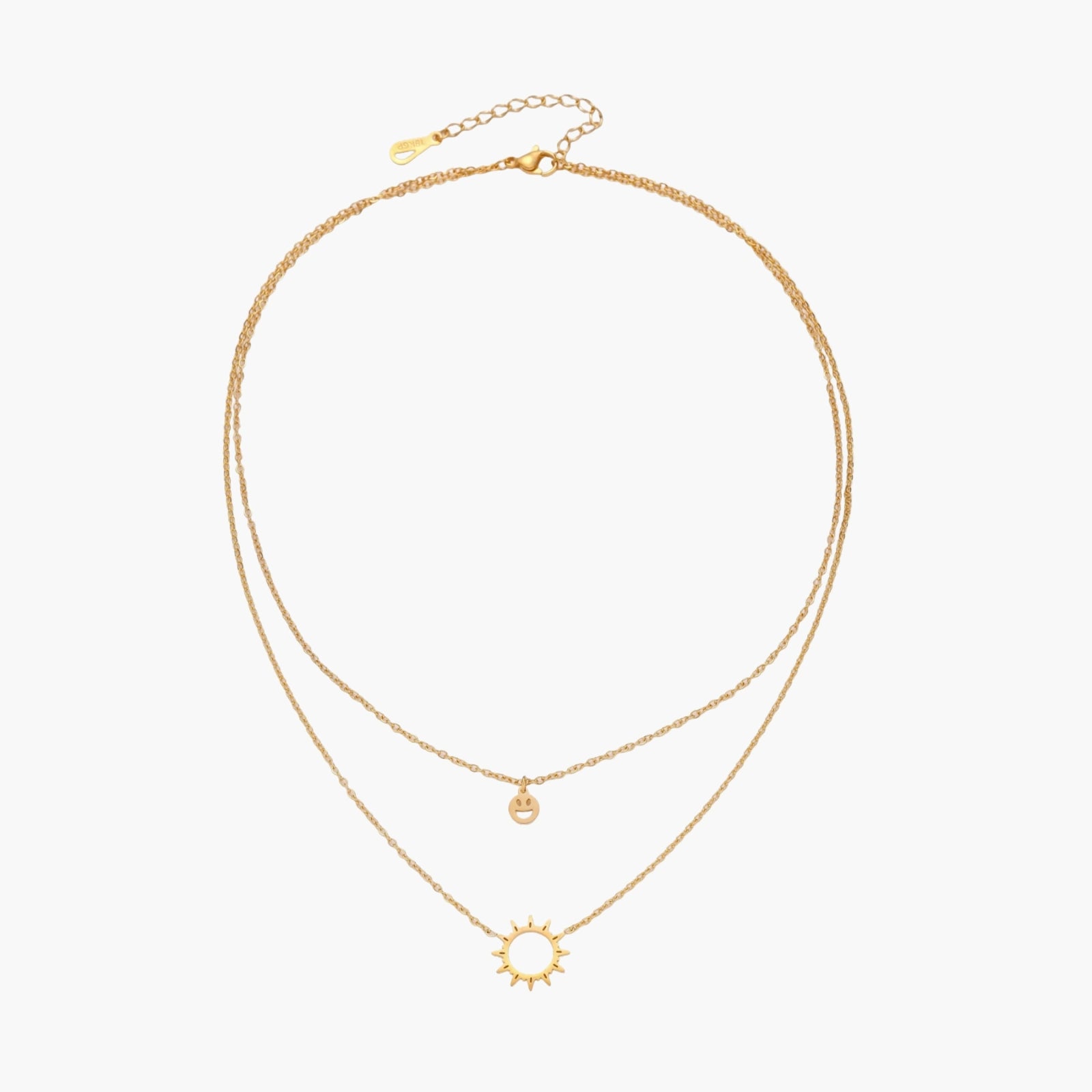 Gold layered necklace set with sunburst and smiley face pendants on delicate chains against white background.
