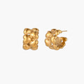 Close-up of gold-plated twisted rope huggie hoop earrings with brushed finish on white background.