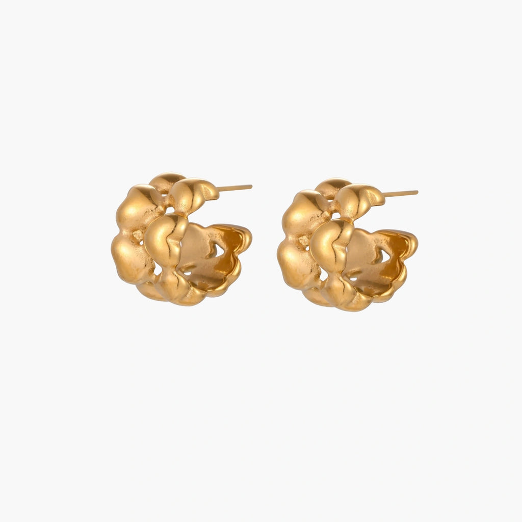 Close-up of gold-plated twisted rope huggie hoop earrings with brushed finish on white background.