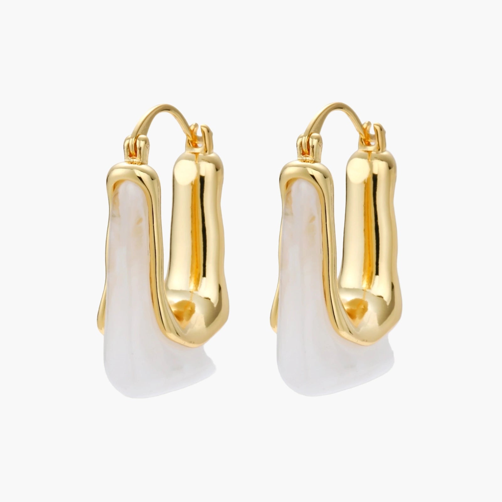 Sculptural gold-plated hoop earrings with flowing curved design and lever-back closure on cream background.
