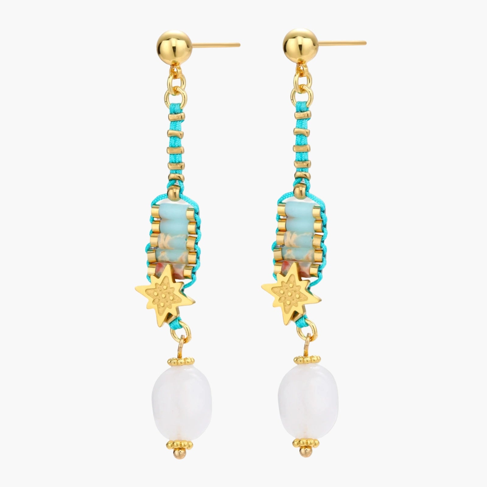 Gold-plated dangle earrings with turquoise threading, star charms, and white pearl beads against cream background.
