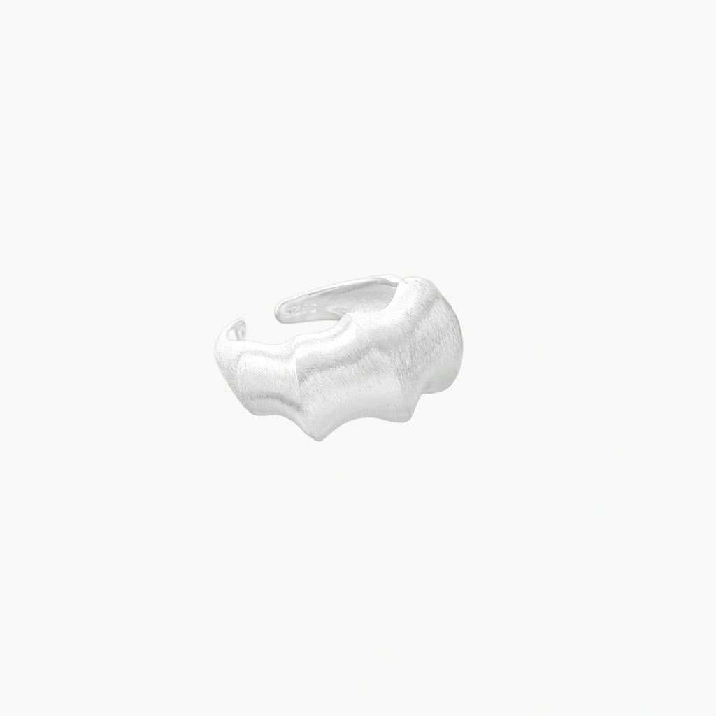 Brushed sterling silver ring with organic wave-like edges and adjustable cuff design on white background