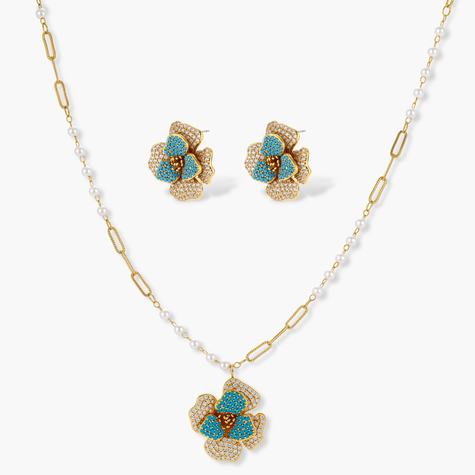 14K gold-plated floral jewelry set with blue cubic zirconia centers and pearl chain details on white background.