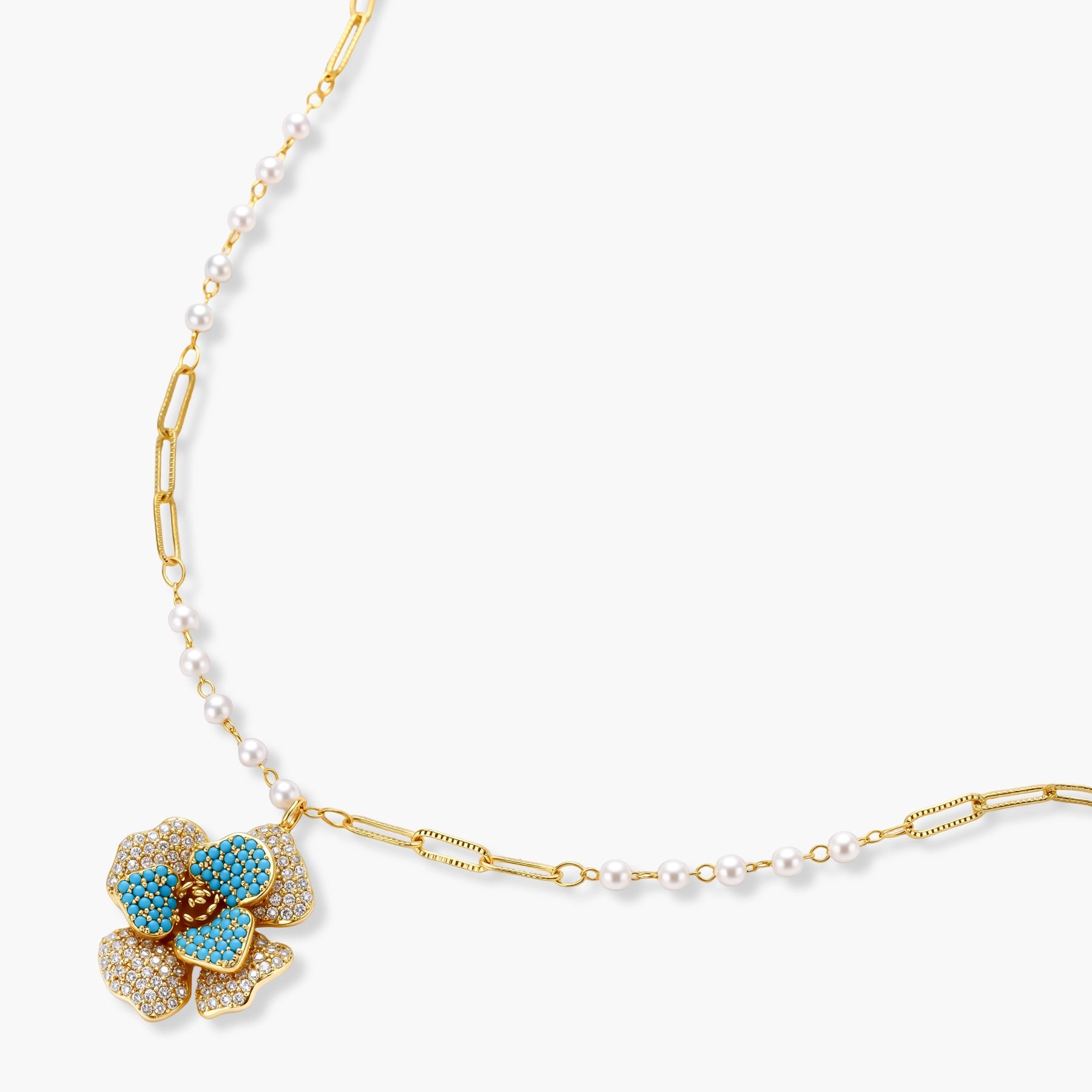 14K gold-plated floral jewelry set with blue cubic zirconia centers and pearl chain details on white background.